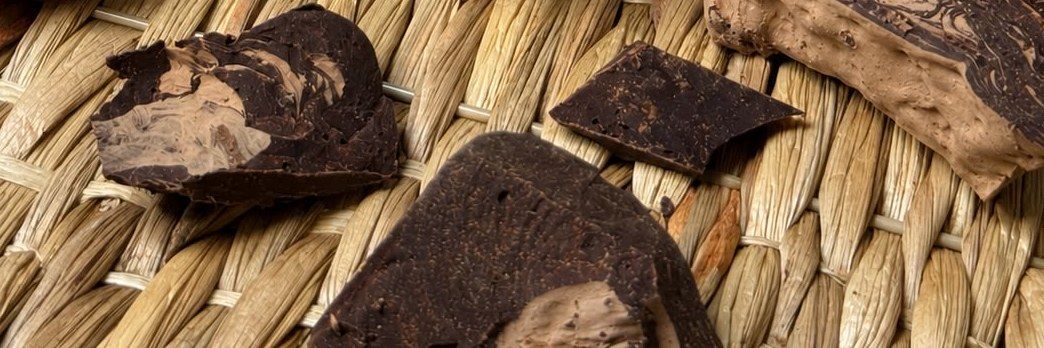 Bryły masy kakaowej na plecionej macie, w ciepłym świetle